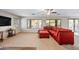 Bright living room featuring a large red sectional, neutral walls, and views of the landscape at 1849 S 225Th Dr, Buckeye, AZ 85326