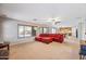 Spacious living room featuring carpeted floors, ample natural light, and a red sectional at 1849 S 225Th Dr, Buckeye, AZ 85326