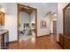 Elegant hallway featuring hardwood floors, an arched doorway, and views of the living spaces at 1905 N Calle Maderas --, Mesa, AZ 85213