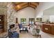 Bright living room featuring a stone fireplace, vaulted ceilings, and views of the outdoor pool area at 1905 N Calle Maderas --, Mesa, AZ 85213