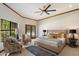 Bedroom with a large window offering outdoor views and natural light, complemented by a contemporary ceiling fan at 1905 N Calle Maderas --, Mesa, AZ 85213