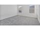 Bright bedroom with plush neutral carpet and two windows at 19984 W Washington St, Buckeye, AZ 85326
