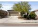Single-story home with desert landscaping, a two-car garage, and a spacious driveway on a sunny day at 19984 W Washington St, Buckeye, AZ 85326