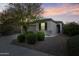 Charming single-story home featuring desert landscaping and a well-maintained front yard at dusk at 19984 W Washington St, Buckeye, AZ 85326
