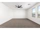 A clean bedroom with neutral carpet, ceiling fan and natural light from the window at 20116 W Monroe St, Buckeye, AZ 85326