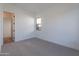 Bright bedroom with neutral carpet, white walls, and a window allowing natural light at 21436 W Meadowbrook Ave, Buckeye, AZ 85396