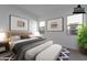 Virtually staged bedroom features neutral walls, carpet, artwork, and a bed at 21436 W Meadowbrook Ave, Buckeye, AZ 85396