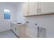 Convenient laundry room features ample storage and a sink with quartz countertops at 21436 W Meadowbrook Ave, Buckeye, AZ 85396