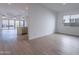 Open concept living room with plank flooring and large windows at 21436 W Meadowbrook Ave, Buckeye, AZ 85396