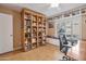 A charming home office boasting custom built-in shelving and a cozy window seat for added comfort and storage at 2217 W Claremont St, Phoenix, AZ 85015