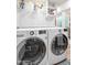 Efficient laundry room equipped with modern front-loading washer and dryer, plus convenient shelving at 2217 W Claremont St, Phoenix, AZ 85015
