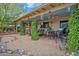 Inviting covered patio with seating areas, lush greenery, and a decorative stone and gravel pathway at 2217 W Claremont St, Phoenix, AZ 85015