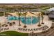 Aerial view of the community pool, lake, shade canopies, tables, and lounge chairs at 23162 E Canary Way, Queen Creek, AZ 85142