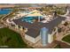 Aerial view of the pool area, cabana, restrooms, seating, and grassy area with a lake backdrop at 23162 E Canary Way, Queen Creek, AZ 85142