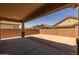 Covered back patio offers a shady spot in an unlandscaped backyard with privacy walls at 23162 E Canary Way, Queen Creek, AZ 85142