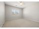 A spacious bedroom with carpet flooring, dual windows, and neutral walls and trim at 23162 E Canary Way, Queen Creek, AZ 85142