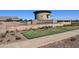 Daytime view of the Barney Farms entrance showcasing a stone water feature, lawn, and plants at 23162 E Canary Way, Queen Creek, AZ 85142