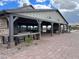 Inviting covered patio with stone fireplace, ceiling fans, and ample seating for outdoor enjoyment at 23162 E Canary Way, Queen Creek, AZ 85142