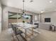 Open dining area with modern light fixture, patio views, and adjacent living area at 23162 E Canary Way, Queen Creek, AZ 85142