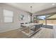 Open dining area with modern light fixture, patio views, and adjacent living area at 23162 E Canary Way, Queen Creek, AZ 85142