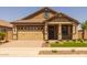 Inviting home exterior featuring a well-manicured lawn, brick accents, and a spacious two-car garage at 23162 E Canary Way, Queen Creek, AZ 85142