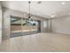 Bright living room with tile floors, large sliding glass doors to the patio, and modern light fixture at 23162 E Canary Way, Queen Creek, AZ 85142