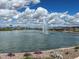 Scenic pond view with a beautiful fountain, lush landscaping, and clear blue skies at 23162 E Canary Way, Queen Creek, AZ 85142
