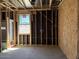 A view of an unfinished bedroom reveals the window and exposed studs in the construction process at 24083 W Bowker St, Buckeye, AZ 85326