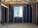 Exposed stud walls and a window define the unfinished bedroom, providing a glimpse of the construction process at 24083 W Bowker St, Buckeye, AZ 85326