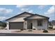 Beautiful single-story home with a neutral-colored exterior, dark gray trim, a front-facing two car garage, and gravel landscaping at 24083 W Bowker St, Buckeye, AZ 85326
