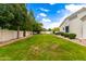 Large backyard with a well-manicured lawn, mature trees, and privacy fence at 2505 E Lehi Rd # 16, Mesa, AZ 85213