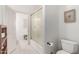 White bathroom features a tub with sliding glass doors, hexagon tile flooring, and a toilet at 2505 E Lehi Rd # 16, Mesa, AZ 85213