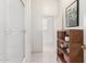 Bright bathroom showcasing white hexagon tile floors, a glass-enclosed shower, and a wood shelving unit at 2505 E Lehi Rd # 16, Mesa, AZ 85213