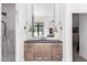 Modern bathroom vanity with dark countertop, sconces, and a shower with white marble tile at 2505 E Lehi Rd # 16, Mesa, AZ 85213