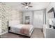 Bright bedroom with a floral accent wall, a bed with white and pink bedding and a ceiling fan at 2505 E Lehi Rd # 16, Mesa, AZ 85213
