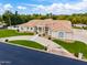 Beige home with a tile roof, curved driveway, and lush green lawn at 2505 E Lehi Rd # 16, Mesa, AZ 85213