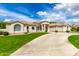 Elegant beige home featuring a well-manicured lawn and curved driveway leading to the entrance at 2505 E Lehi Rd # 16, Mesa, AZ 85213
