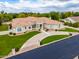 Beige home featuring desert landscaping, manicured lawn, and a tile roof in a serene neighborhood at 2505 E Lehi Rd # 16, Mesa, AZ 85213