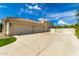 Side view of a beige home showcasing a large garage, ample driveway, and tile roof at 2505 E Lehi Rd # 16, Mesa, AZ 85213