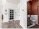 A hallway with white walls and wood floors leading to a half bathroom with red walls at 2505 E Lehi Rd # 16, Mesa, AZ 85213
