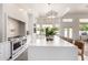 Modern kitchen with an island bar, sleek white countertops, and views to the outdoor pool through a bay window at 2505 E Lehi Rd # 16, Mesa, AZ 85213