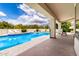 Covered patio with lounge seating overlooking the backyard pool and lush greenery at 2505 E Lehi Rd # 16, Mesa, AZ 85213