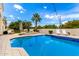Sparkling blue pool with tiled edge, palm tree, and lounge seating under a sunny sky at 2505 E Lehi Rd # 16, Mesa, AZ 85213