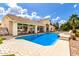 Large pool with blue tile, surrounding patio, covered porch, and well-manicured lawn at 2505 E Lehi Rd # 16, Mesa, AZ 85213