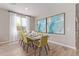 Bright dining room with modern art, a wooden table, and green chairs, bathed in natural light at 2637 N 195Th Dr, Buckeye, AZ 85396