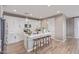 Bright kitchen features an island with bar stool seating, white cabinets and subway tile backsplash, and wood-look flooring at 2637 N 195Th Dr, Buckeye, AZ 85396