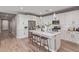 Modern kitchen with white cabinets, stainless steel appliances, a central island with stools, and ample counter space at 2637 N 195Th Dr, Buckeye, AZ 85396