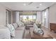 Airy living room with dual sofas, wood-look flooring, large windows with sheers, and modern decor at 2637 N 195Th Dr, Buckeye, AZ 85396