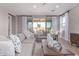 Open-concept living area with neutral colors, wood-look floors, and access to an outdoor patio at 2637 N 195Th Dr, Buckeye, AZ 85396
