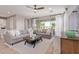Bright living room featuring stylish gray sofas, a modern coffee table, and sliding doors to outdoor space at 2637 N 195Th Dr, Buckeye, AZ 85396